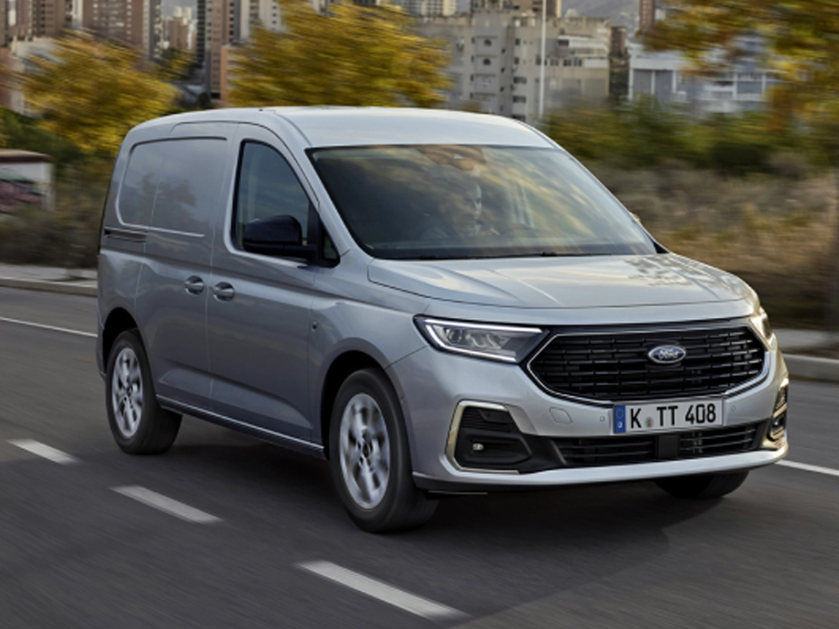 Bild zeigt einen silberfarbenen Ford Transit Connect auf einer Straße in der Stadt
